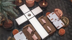 Ein Loungebereich mit Sitzgelegenheiten, Topfpflanzen und einem Kamin.