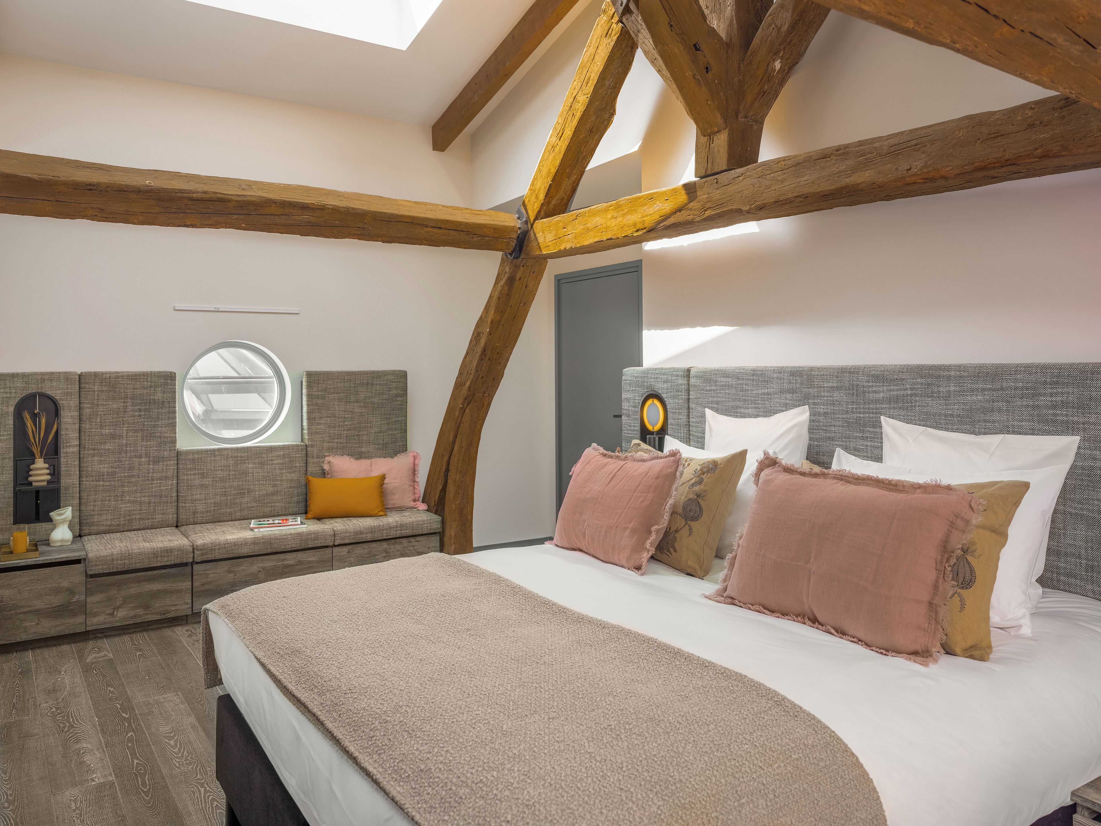 Un dormitorio con una cama grande, una ventana y vigas de madera.