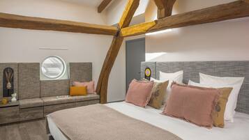 Un dormitorio con una cama grande, una ventana y vigas de madera.