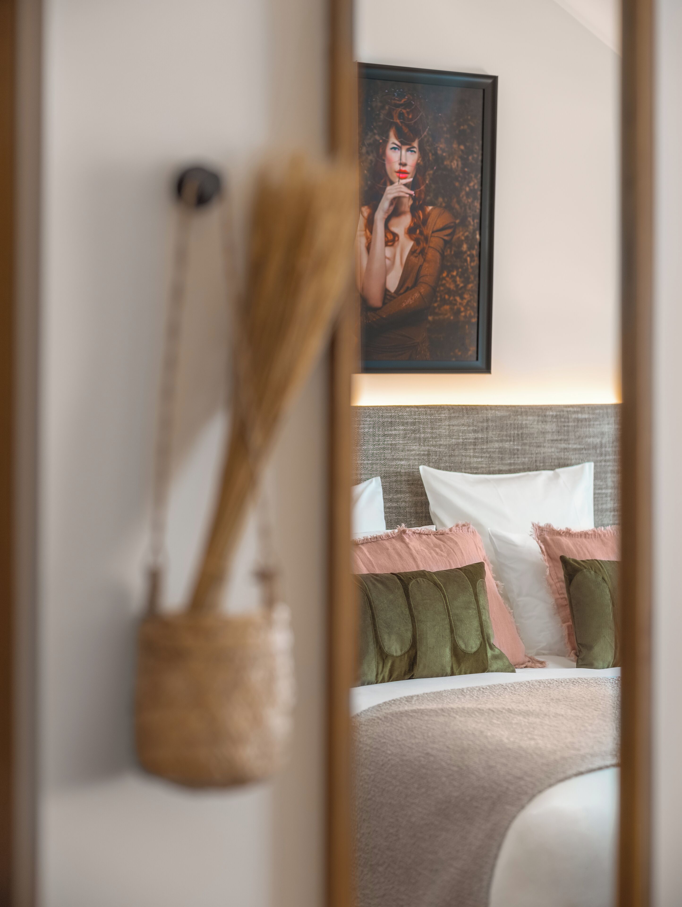Une chambre à coucher avec un lit, des oreillers et une œuvre d’art encadrée accrochée au mur.