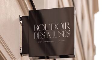 A sign for "BOUDOIR DES MUSES" indicating a hotel, cocktail bar, and salons.