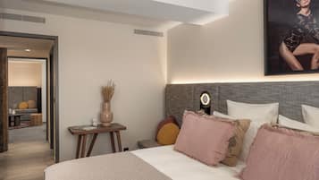 Een moderne hotelkamer met een groot bed, een nachtkastje met een vaas en een spiegel aan de muur.
