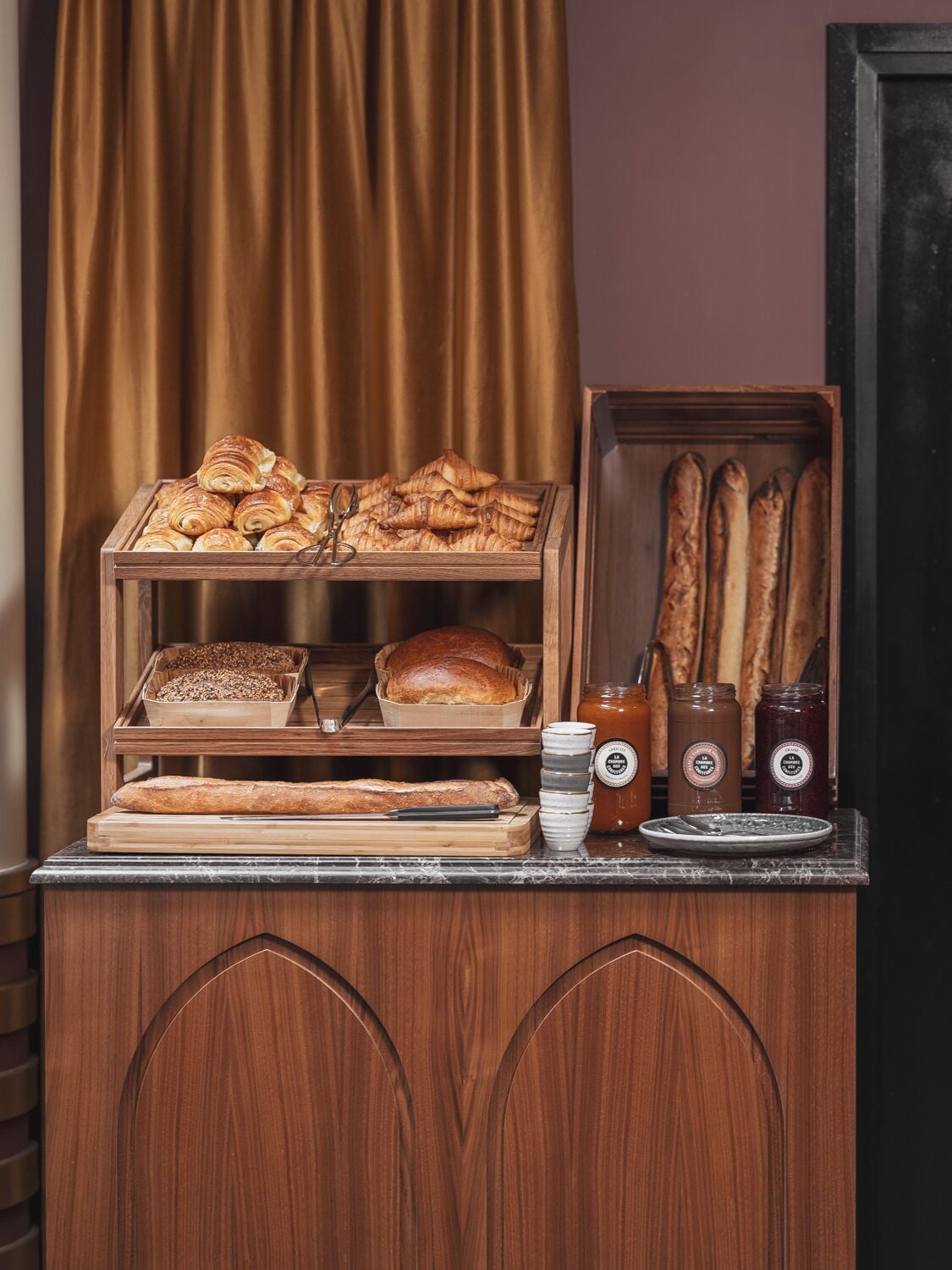 A bakery display with pastries, bread, and condiments.