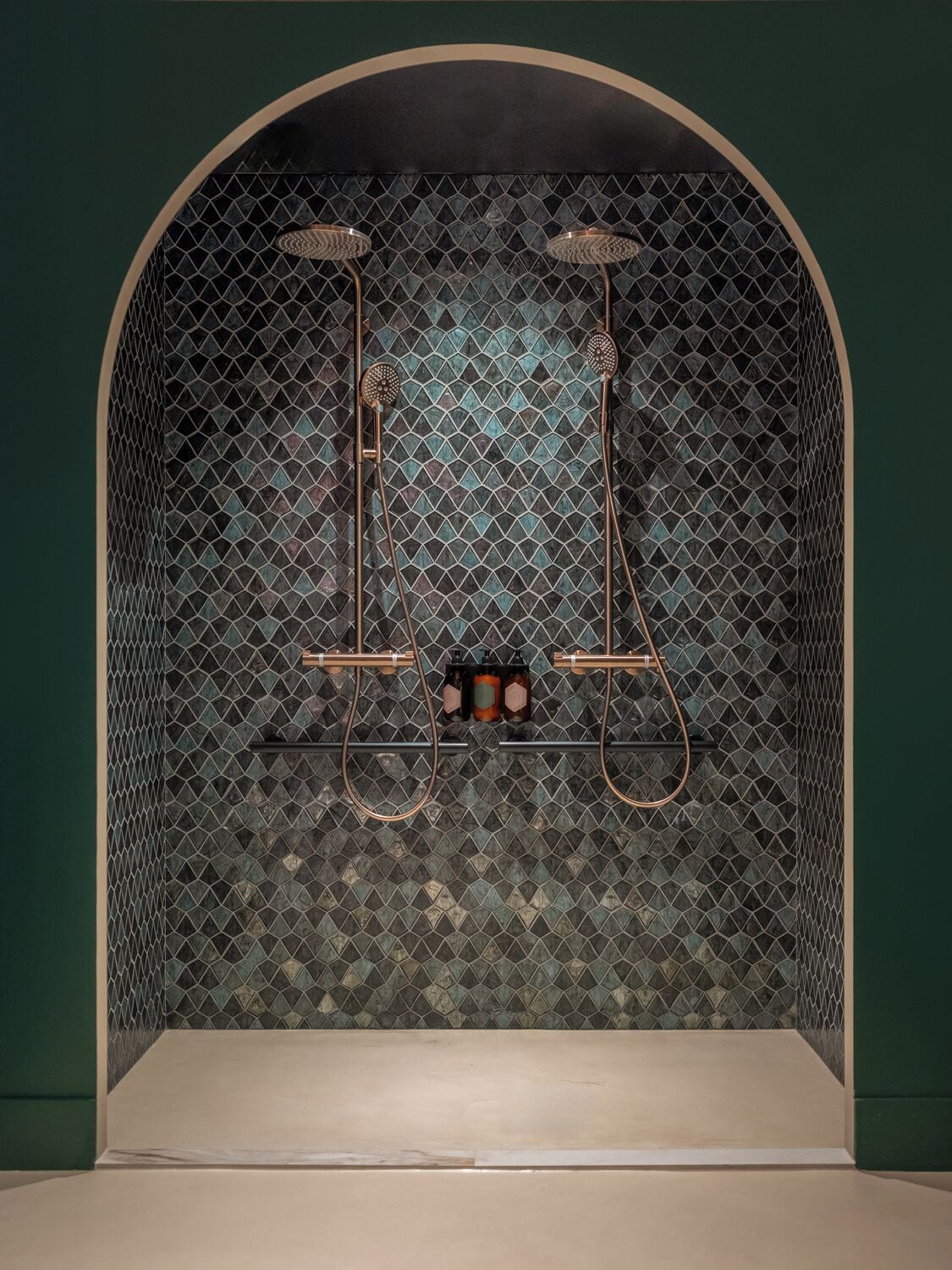 Zona de spa con cabina de ducha, pared con azulejos y un banco.