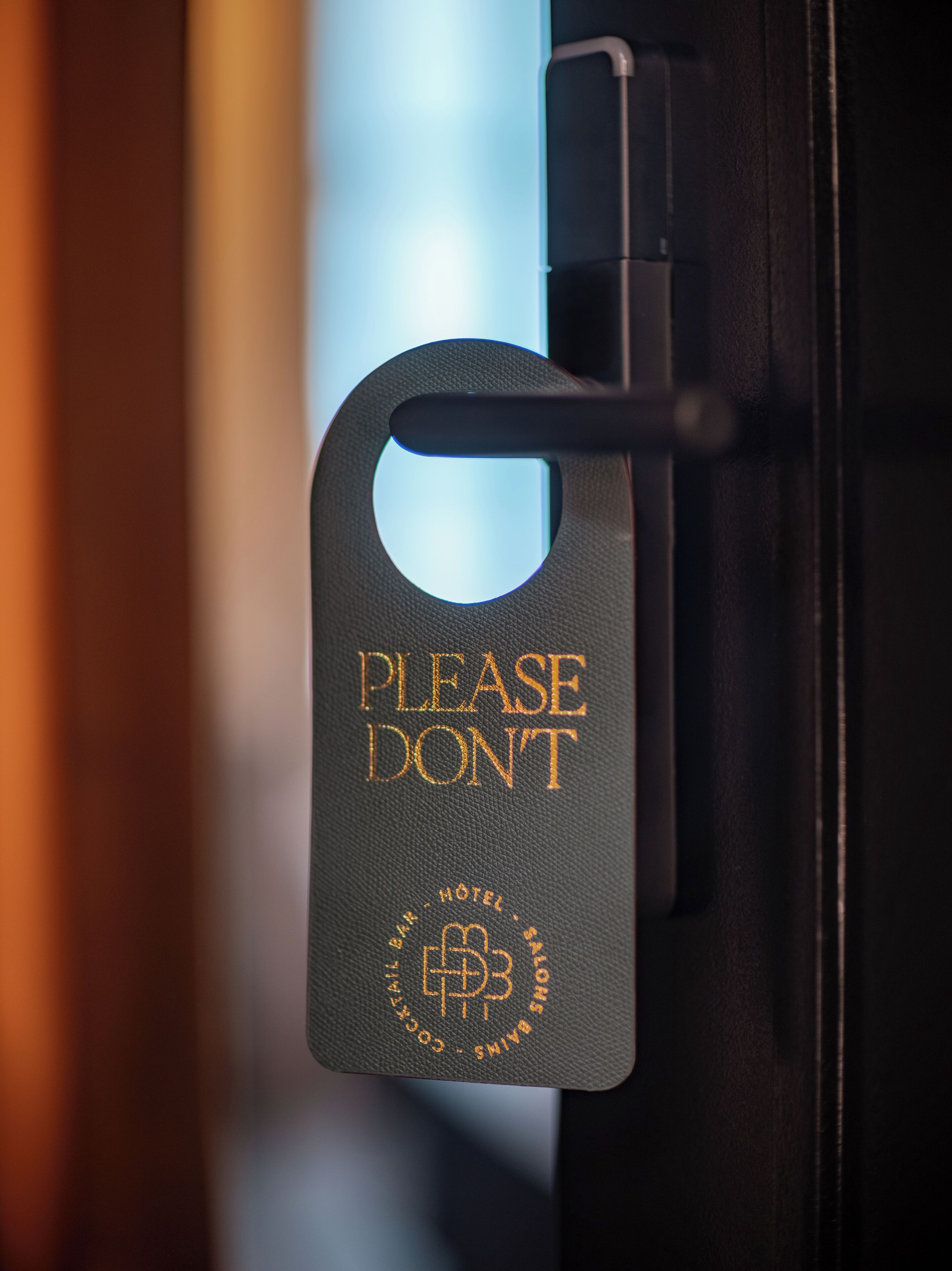 Una puerta con un cartel que dice 'No molestar' y el logo de un hotel.