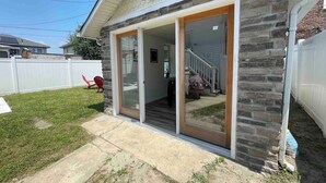 Una casa con fachada de piedra, un porche cubierto y una escalera visible que lleva a un nivel superior.