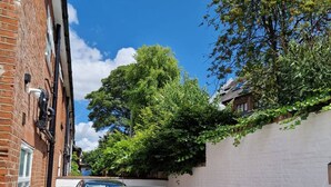 A narrow alleyway with a parked car, brick buildings, and greenery. - Stay Norwich Apartments Riverside House Apart-5 (Norwich)