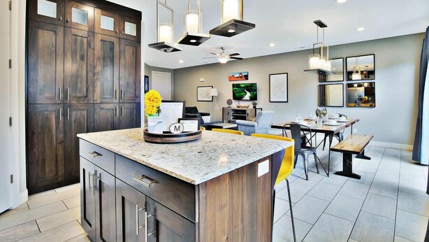 A modern kitchen with dark wood cabinets, a granite countertop, and pendant lighting. - Entrada at Moab 420 and 424 and 428 (Moab)