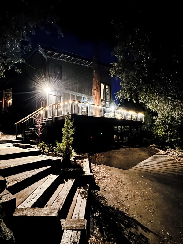 A modern building with a wooden deck and a staircase leading to a covered area.