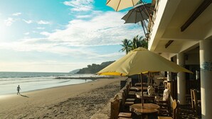 Un restaurant situé en bord de mer, avec une terrasse offrant une vue sur l’océan.