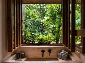 A bathroom with a window view of a lush garden. - Boca de Agua Bacalar A Member of Design Hotels (Xul-Ha)