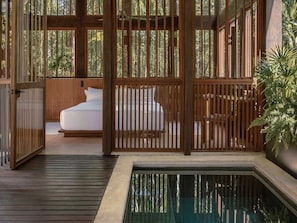 A private room with a bed, a small table, and a view of the outdoors through a wooden partition. - La Valise Bacalar, Member of Design Hotels (Xul-Ha)