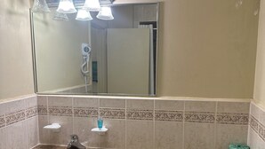 A bathroom with a granite countertop sink, a mirror above it, and a toilet. - Kingston Motel (Kingston)