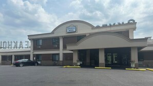A motel with a sign reading "Kingston Motel" and a parking lot with a black car. - Kingston Motel (Kingston)