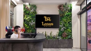 A reception desk with a sign reading "Lenus Hotel" and a wall of green plants behind it. - Lenus Hagia Sophia Hotel (Istanbul)