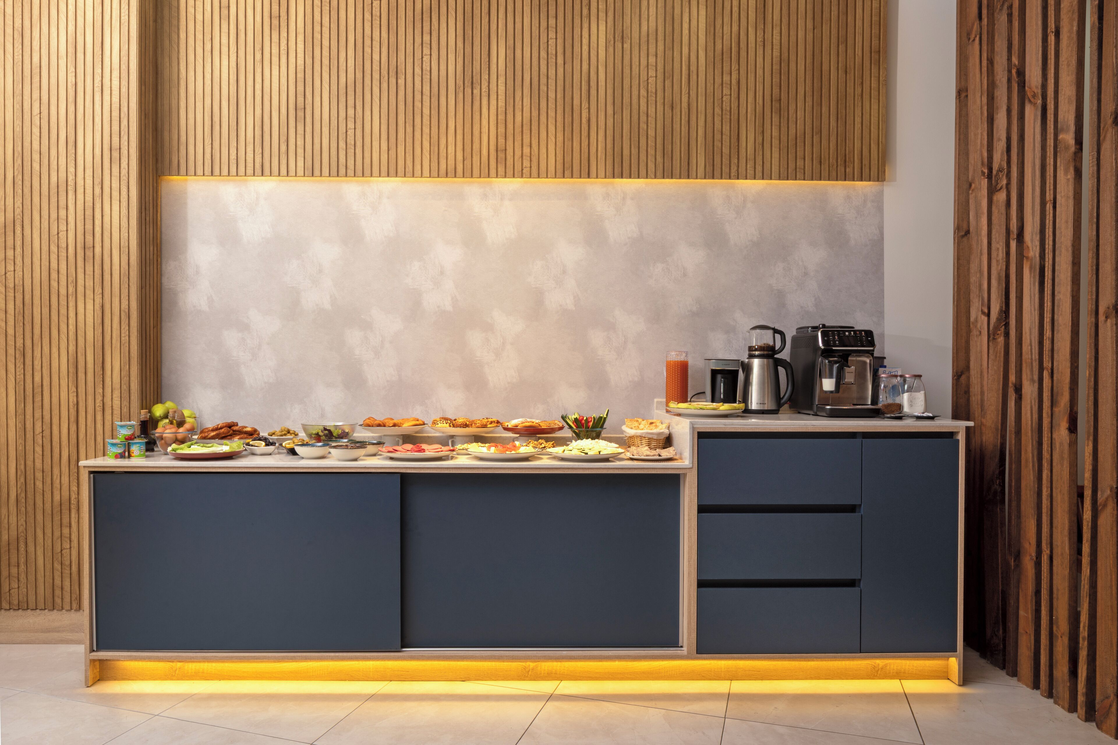 Una cocina moderna con una isla integrada, paneles de madera en las paredes y una estación de café.
