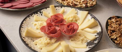 A variety of food items on a table, including sliced meats, cheeses, and nuts.