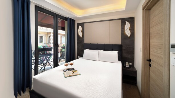 A hotel room with a large bed, a balcony with a view, and a modern ceiling light. - Lenus Hagia Sophia Hotel (Istanbul)
