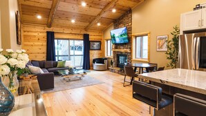 A cozy log cabin interior with a living room, dining area, and kitchen. - SNOW BUNNY - Game Room - Hot Tub - Fire Pit (Big Bear Lake)