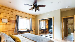 A wooden-paneled room with a bed, a desk, and a ceiling fan. - SNOW BUNNY - Game Room - Hot Tub - Fire Pit (Big Bear Lake)