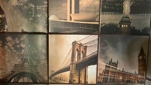 Un baño con pared de azulejos que muestra monumentos famosos.