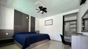Un dormitorio moderno con cama, escritorio y armario.