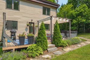 A house with a covered porch, potted plants, and a stone pathway leading to the entrance. - Muskoka Zen, Outdoor Jacuzzi Spa, Ski or Hike 3 Bedroom 2 Bath (Huntsville)