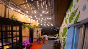 An indoor corridor with a punching bag, exercise equipment, and potted plants. - Sun Backpackers (Quito)