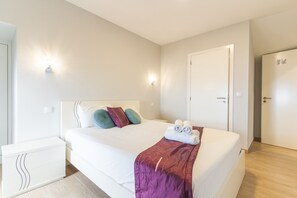 Een hotelkamer met een bed, nachtkastjes, een kledingkast en een deur.