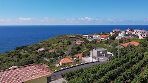 Un village côtier avec des maisons à étages, une route sinueuse et une vue sur la mer.