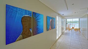 Un pasillo con tres grandes obras de arte colgando en la pared que representan escenas submarinas.