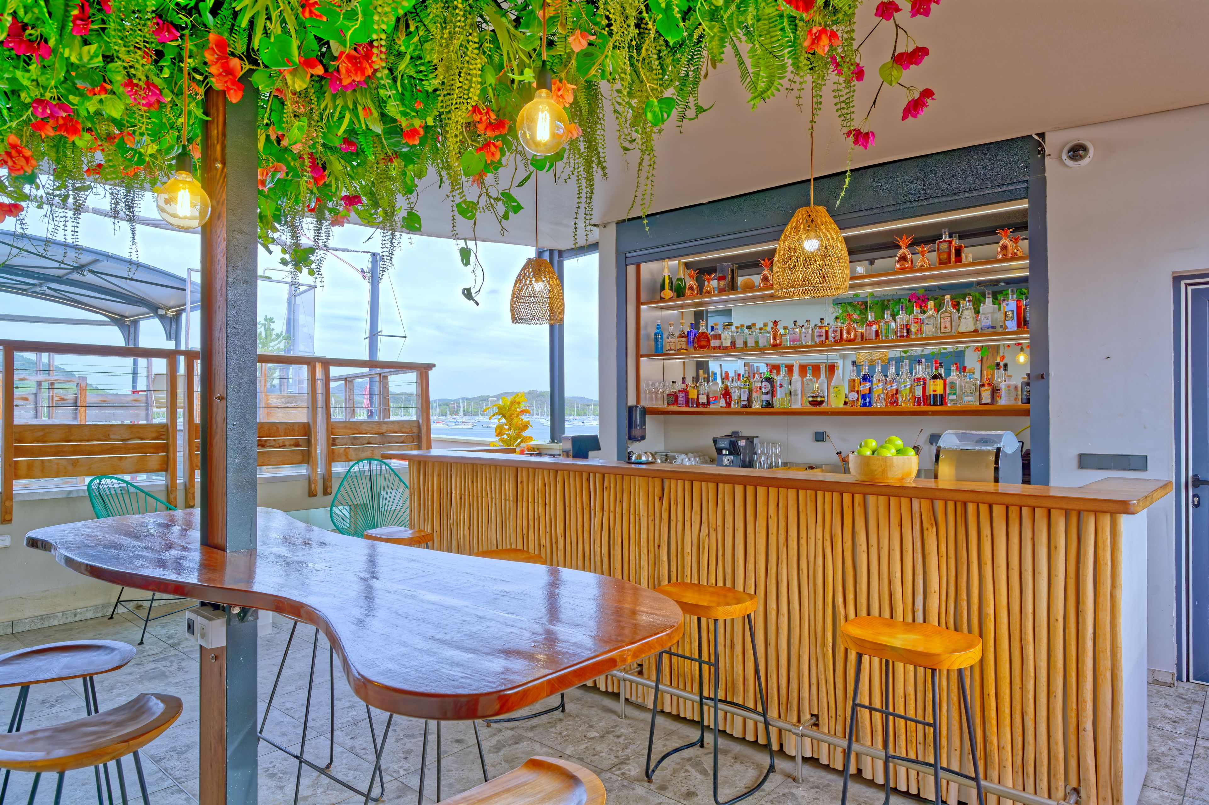 Een bar met houten krukken, een toog en diverse flessen.