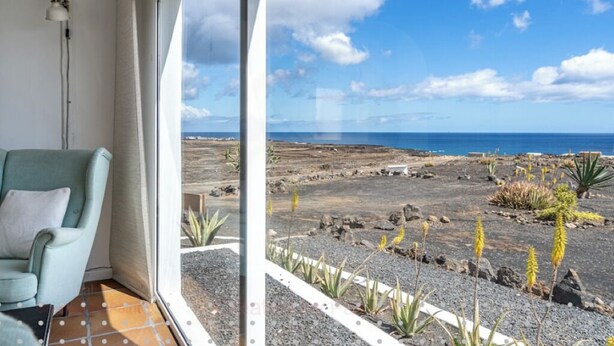 Habitació amb vista a un paisatge rocosós i l'oceà.