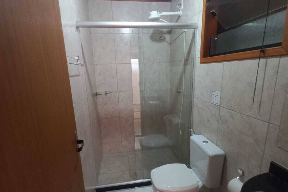 Een moderne badkamer met een douchecabine van glas, een toilet, een bidet en een wastafel.