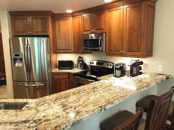 Enjoy cooking in this fully equipped kitchen with a refrigerator, microwave, and oven, along with ample workspace and a coffee maker.
