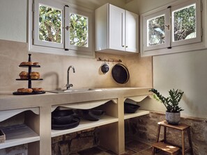 Una cocina con un tres niveles de bandeja de servir, un lavabo y una planta en maceta.