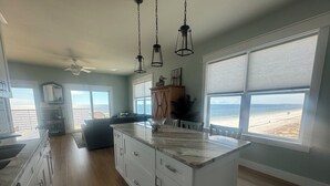 A spacious kitchen with a large island, wooden cabinets, and a view of the beach. - Closest to the sand and surf and no better view than Water’s Edge in the sand  (Port St. Joe)