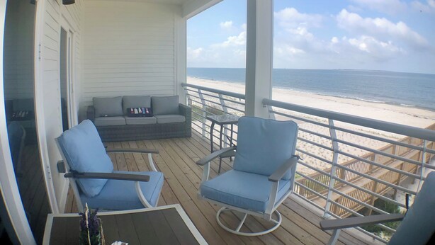 A covered deck with a sofa and two chairs, overlooking a beach. - Closest to the sand and surf and no better view than Water’s Edge in the sand  (Port St. Joe)