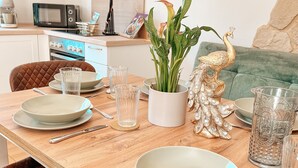 A dining table set with plates, glasses, and cutlery, a decorative plant, and a peacock figurine. - Panorama retreat; incl. private whirlpool (Bad Kötzting)