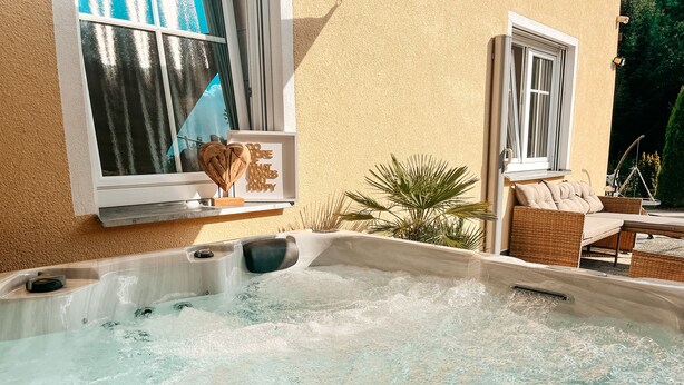 A hot tub with a wooden bench and a framed sign above it. - Panorama retreat; incl. private whirlpool (Bad Kötzting)