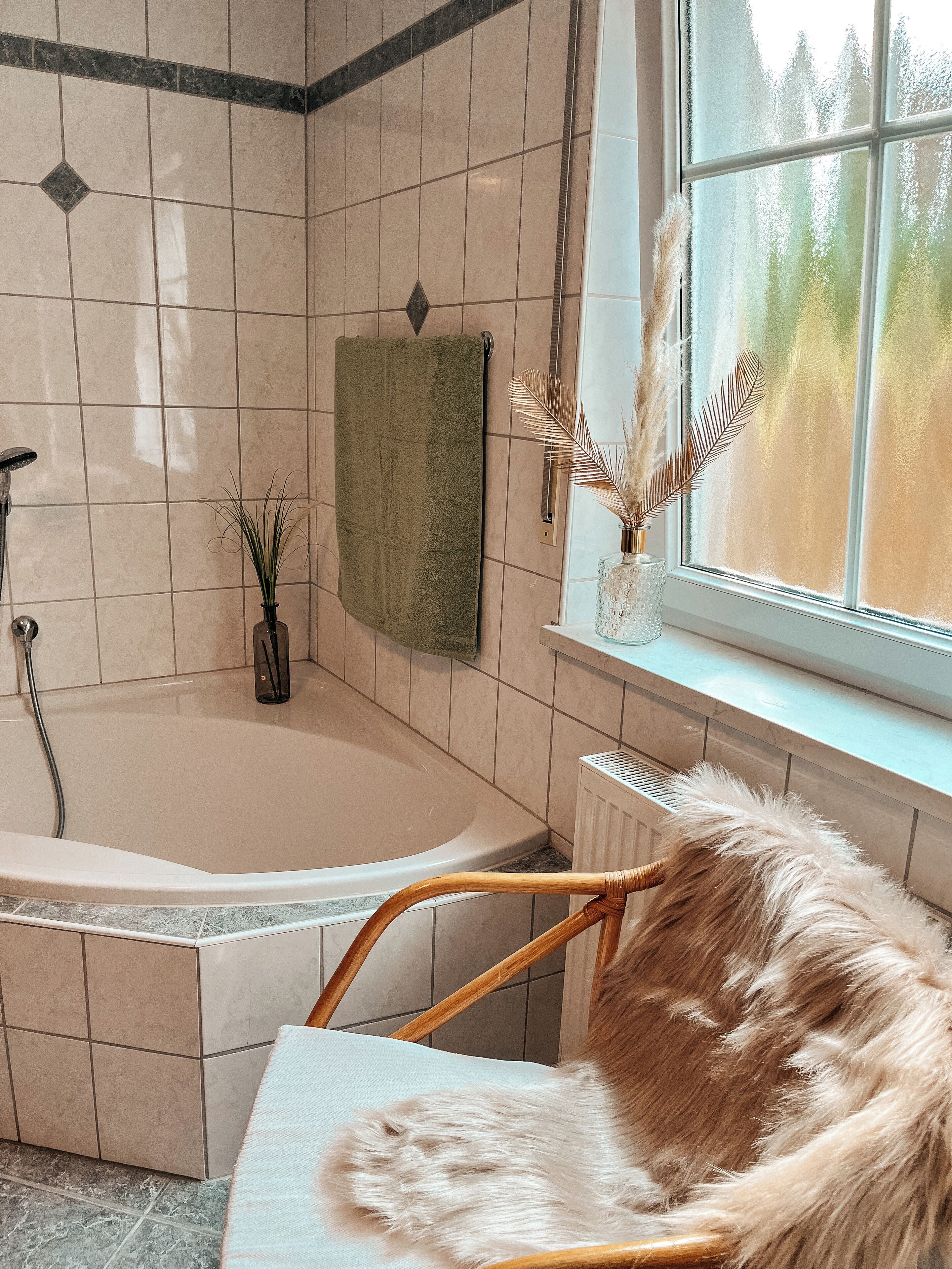 Ein Badezimmer mit einer Badewanne, einem Handtuchhalter, einem Fenster mit Aussicht und einem Stuhl.