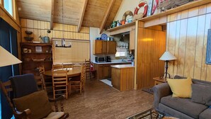A cozy cabin interior with a dining area, kitchen, and seating space. - Rustic Lakeview Lodge at Bass Lake. Bookable boat slip! (Bass Lake)