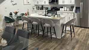 A modern kitchen with white cabinets, stainless steel appliances, and pendant lighting. - Happy, Luxury and Fun Space. Mins to NRG, MedCntr and downtown Houston  (Houston)