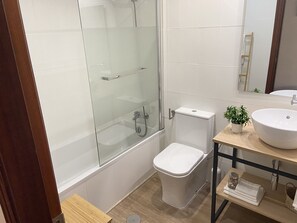 Bañera, secador de pelo, toallas y jabón