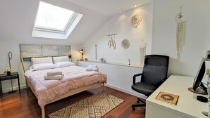 A bedroom with a bed, a desk, a chair, a skylight, and wall decorations. - Housing San Lorenzo by Sharing Co (Málaga)