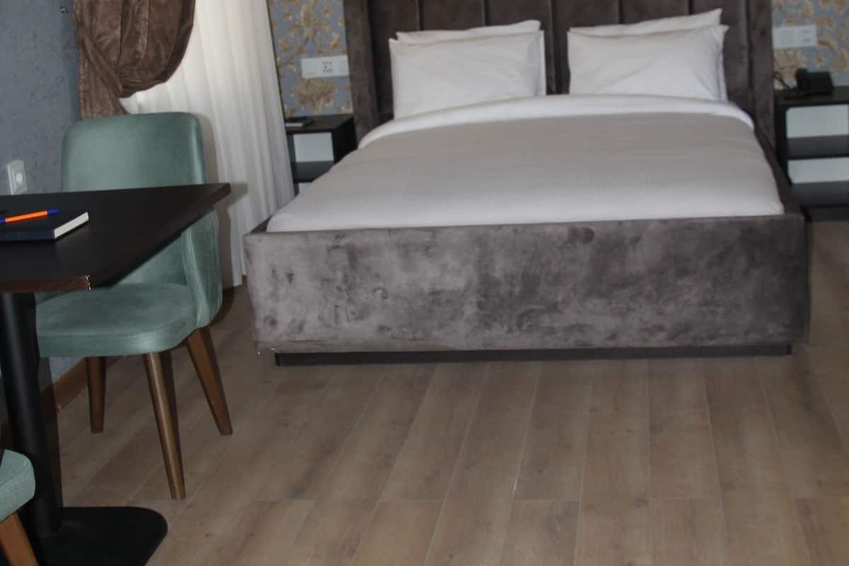 A bedroom with a large bed, two bedside tables, a desk, and a chair.