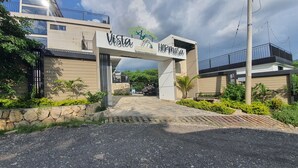 A modern building with a sign reading "Vista Hermosa" and a logo. - Vista Hermosa Glamping & Cabañas (La Mesa)