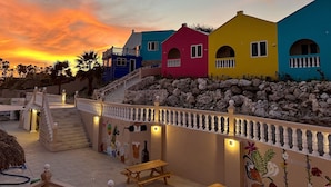 A colorful building with a staircase leading up to it, a railing, and a mural on the wall. - MERAKII SEAVIEW ESCAPE CURACAO (Willemstad)