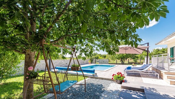 A backyard with a swing set, a pool, and a patio area with lounge chairs. - Holiday Home Endi - rural escape with pool (Danilo Kraljice)