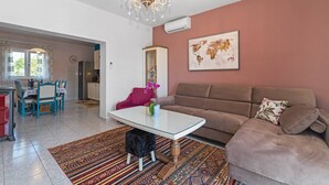 A living room with a brown sofa, a white coffee table, and a colorful rug. - Holiday Home Endi - rural escape with pool (Danilo Kraljice)